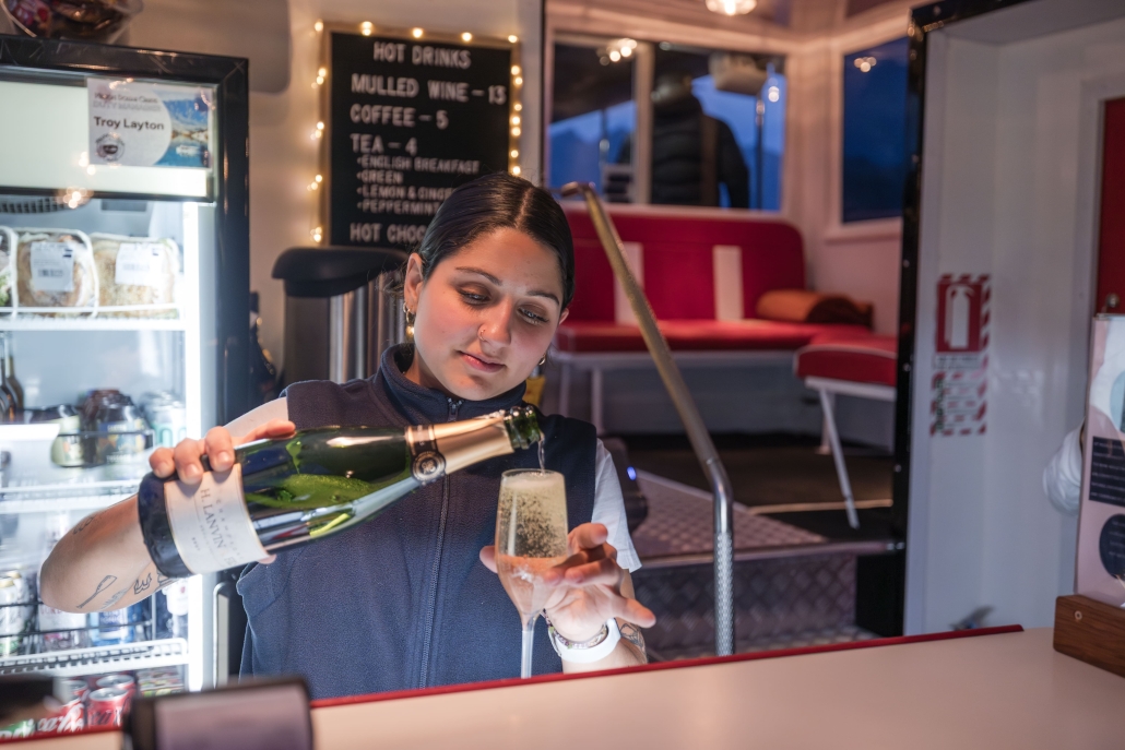 Woman pouring champagne into a flute on a cruise.